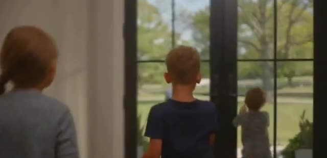  Children watch their father power through the window