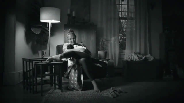  mom turning off the phone with her feet while the baby sleeps