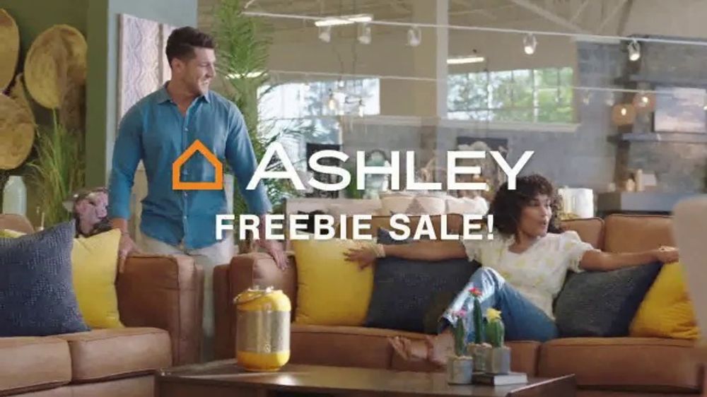 ¿Quién es la actriz que aparece en el anuncio de Ashley Furniture en la sala de estar?